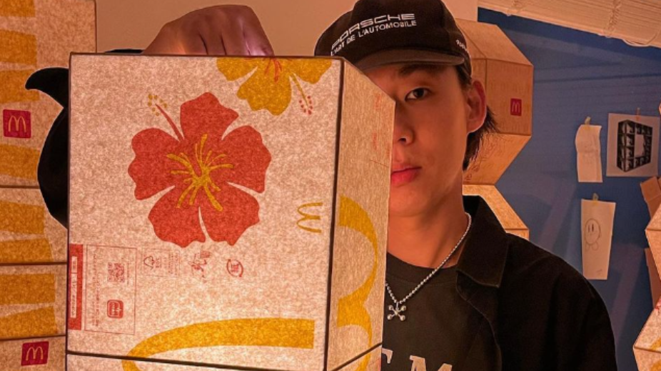 Gyuhan Lee met zijn lamp van papieren McDonald's tassen